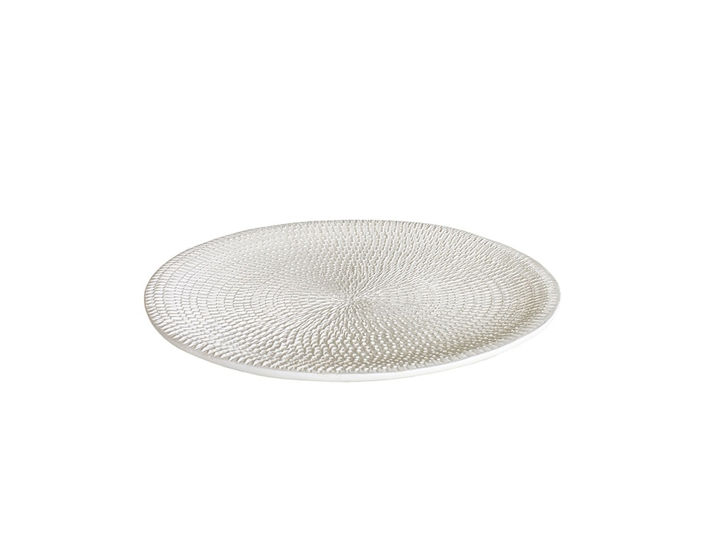 medium round white ceramic plate with circular finishes behind a white background.