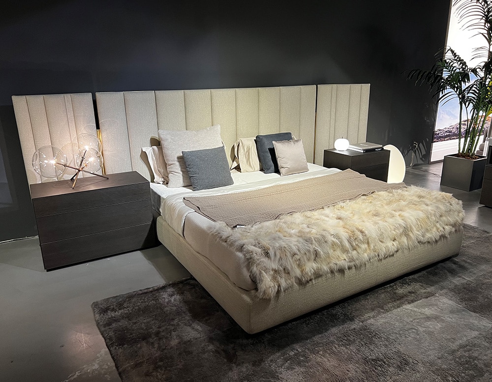 bed in white fabric with base made of white wood accompanied by decorative cushions