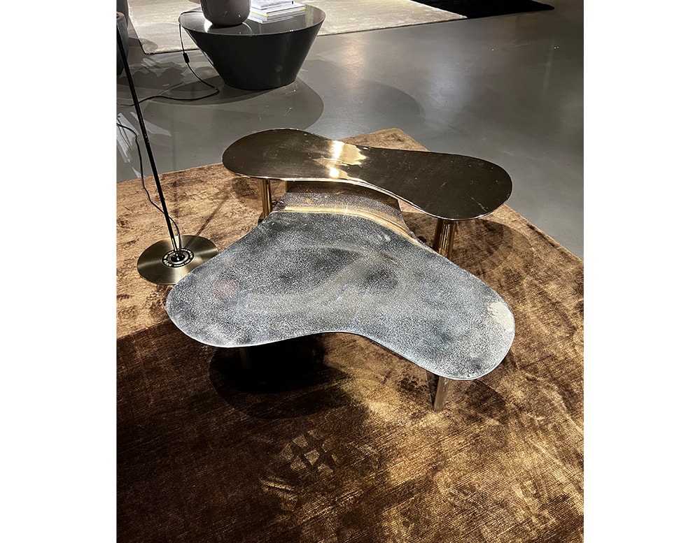 from above view of two sand-cast coffee tables in black brass finish with white details and gold-colored metal legs