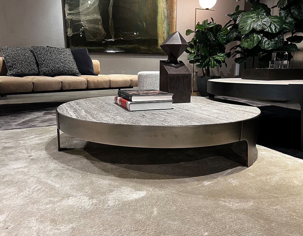 circular centerpiece with black steel base and stone top in a room.