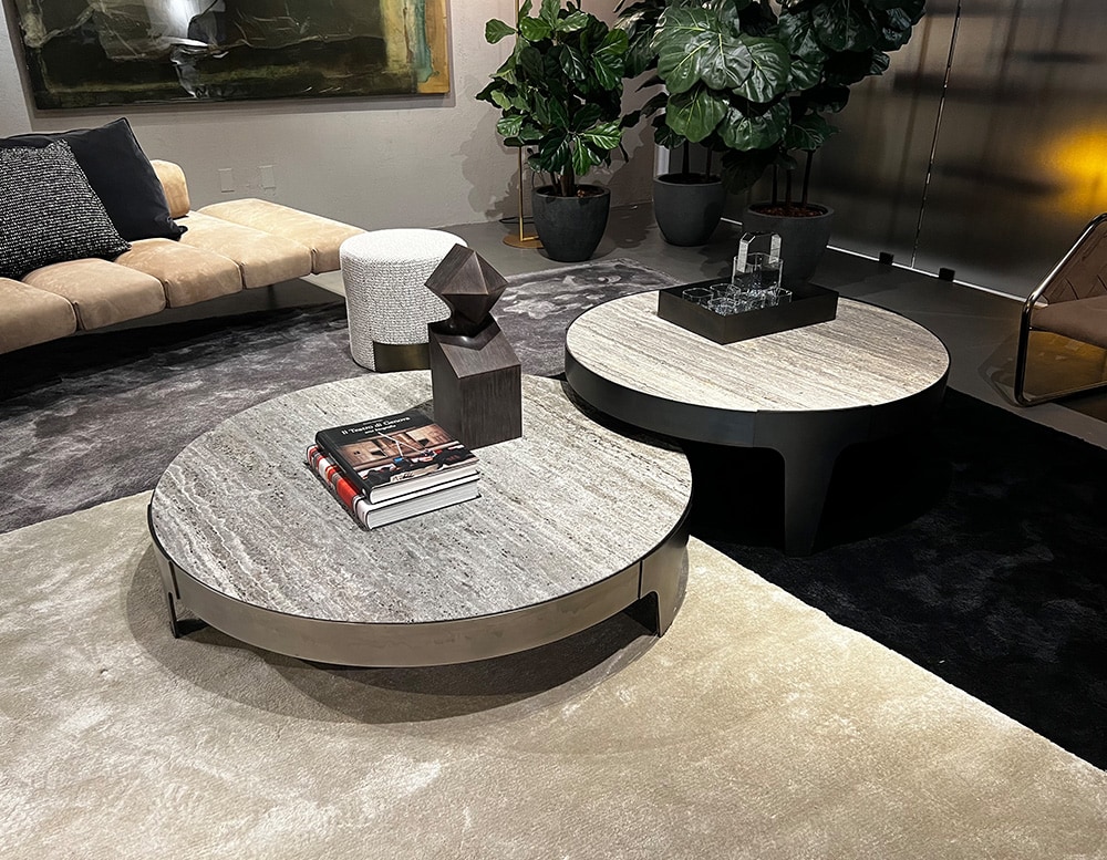 circular tables arranged in pairs made of stone and steel with different shades of gray colors.