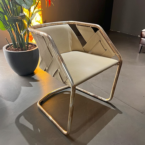 chair made from brown leather and a base with gold metal tubes