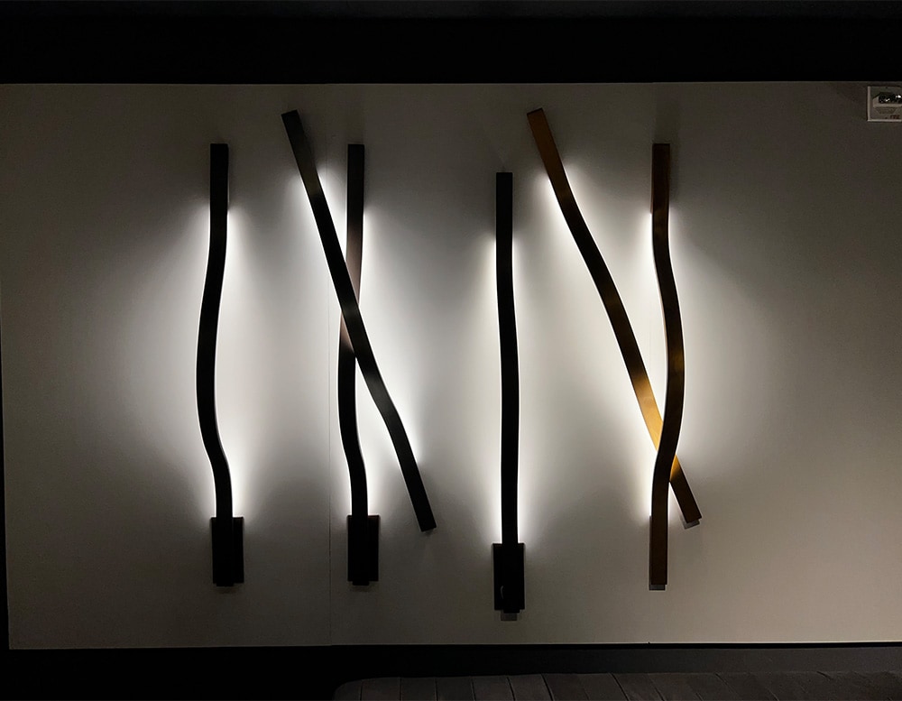 Six ribbon-shaped wall lamps in black and bronce burnished brass finish