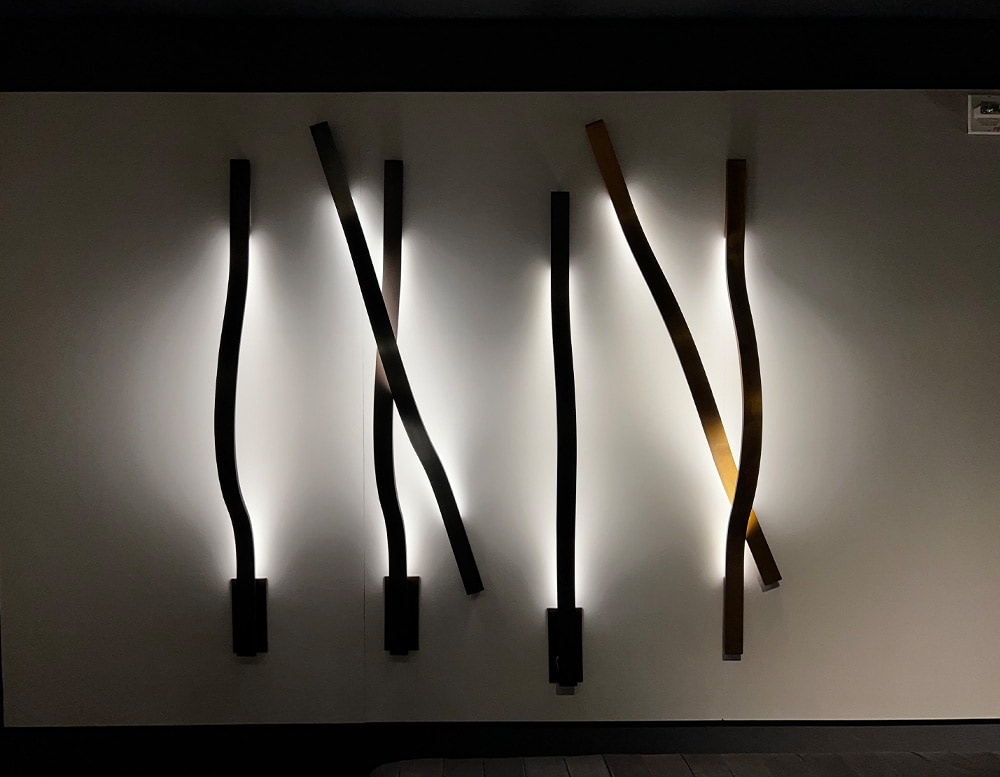 Six ribbon-shaped wall lamps in black burnished brass finish