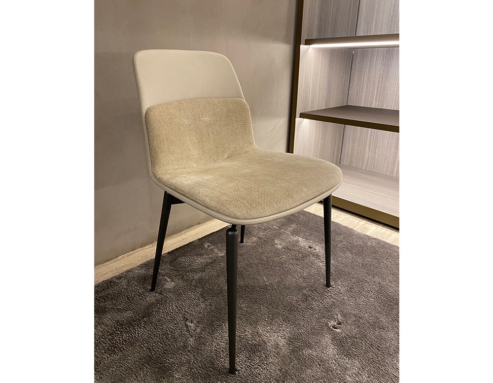 Dining room chair made of aluminum and upholstered in beige leather with a smoke-shaped design in a room