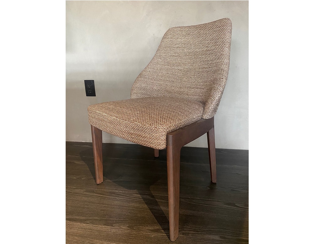 dining chair made of eucalyptus base and upholstered in brown fabric in its finishes in a room
