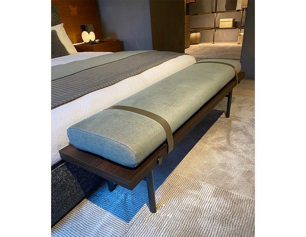 bed bench made of eucalyptus and upholstered in blue fabric and two leather straps in a room