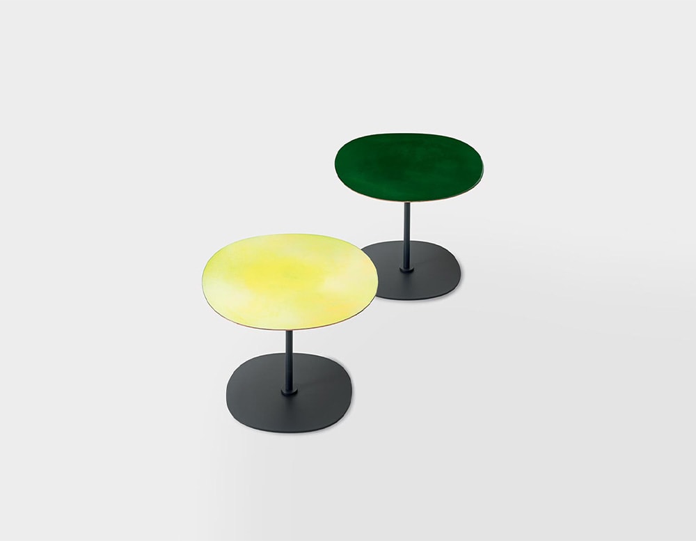 two side tables with a black base, one with a green top and the other with a yellow top