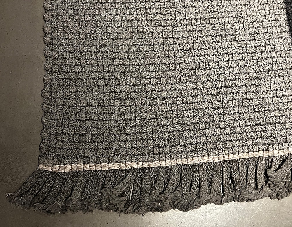 one-tone gray rug hand-woven with synthetic fibers.