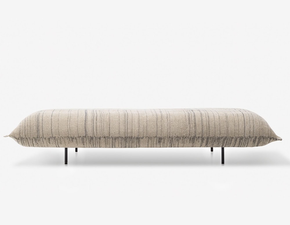 Platform composed of a single wide seat cushion upholstered in fabric in different beige tones and matte steel feet