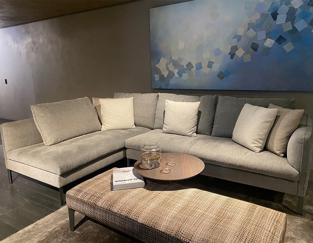 sofa made of pewter base and upholstered with fabric in different shades of gray ina living room