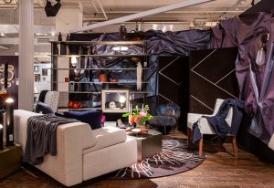 A luxurious living space featuring plush seating, dramatic drapery, sleek shelving, and ambient lighting, creating a cozy yet elegant atmosphere