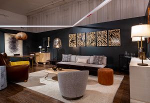 A modern living room with a sleek white sofa, accent chairs, and warm lighting, featuring wooden elements and abstract wall art