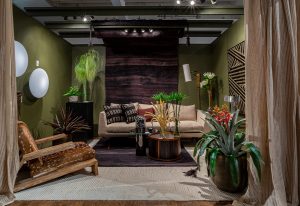 A cozy living space with earthy tones, featuring a beige sofa, wooden coffee table, lush greenery, and warm ambient lighting