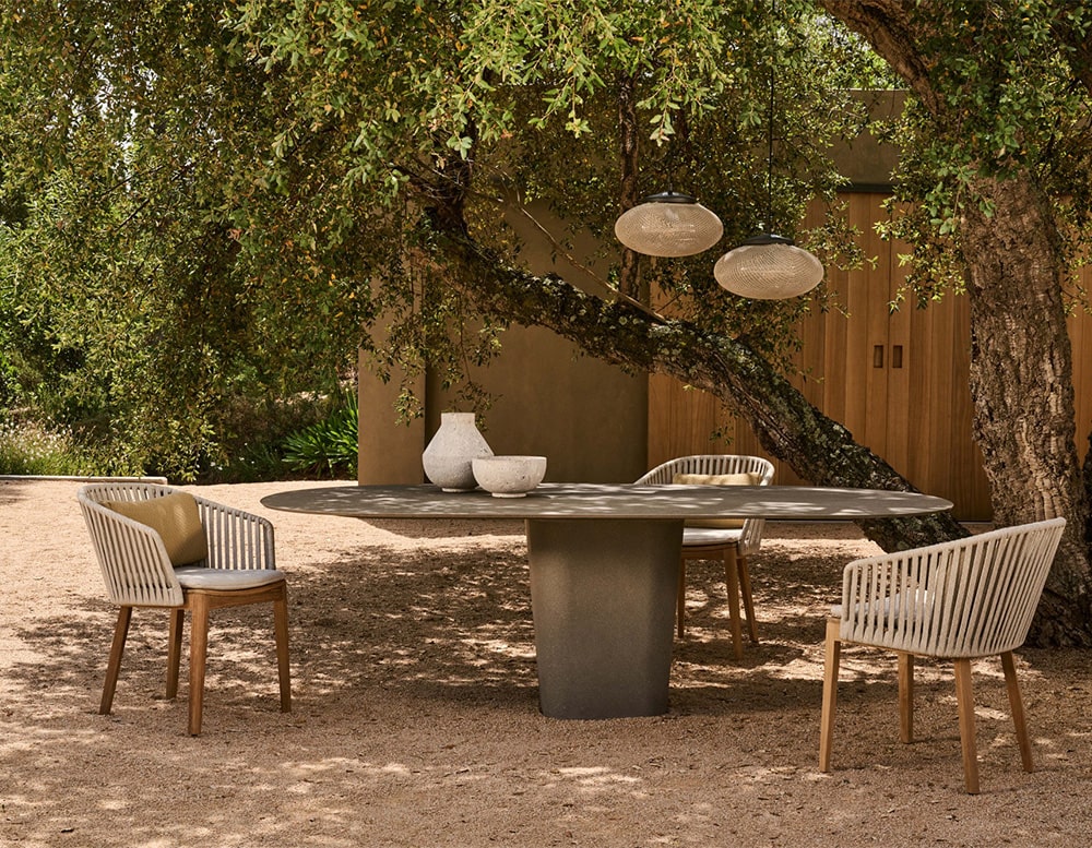 oval dining table made with lava stone and metal base in a dark gray tone