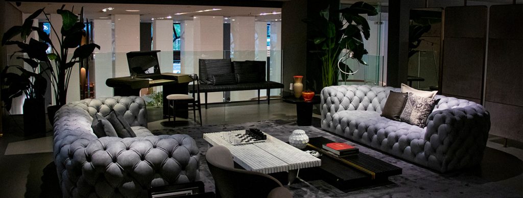 A refined lounge area featuring tufted seating, a marble coffee table, and sleek black furniture, creating a sophisticated ambiance