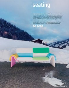 Colorful modern sofa set against a snowy mountain backdrop with a wooden cabin in the distance