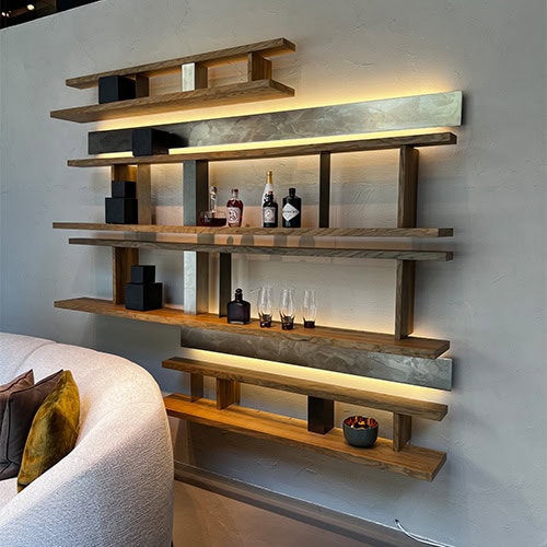 A sophisticated wall-mounted storage solution with floating wooden shelves and soft LED illumination, blending practicality with refined design.