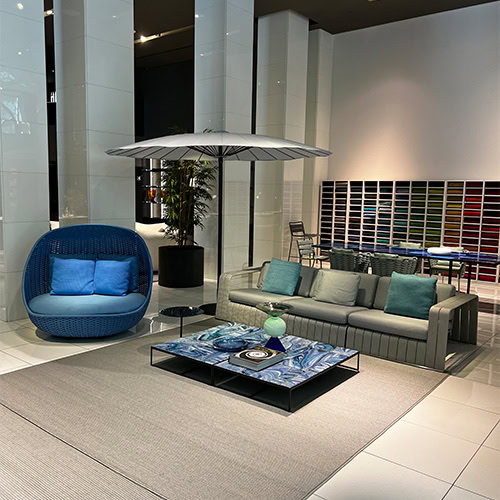 A modern showroom display featuring the Frame Composition Set, highlighting sleek seating, a stylish coffee table, and a well-lit, inviting ambiance