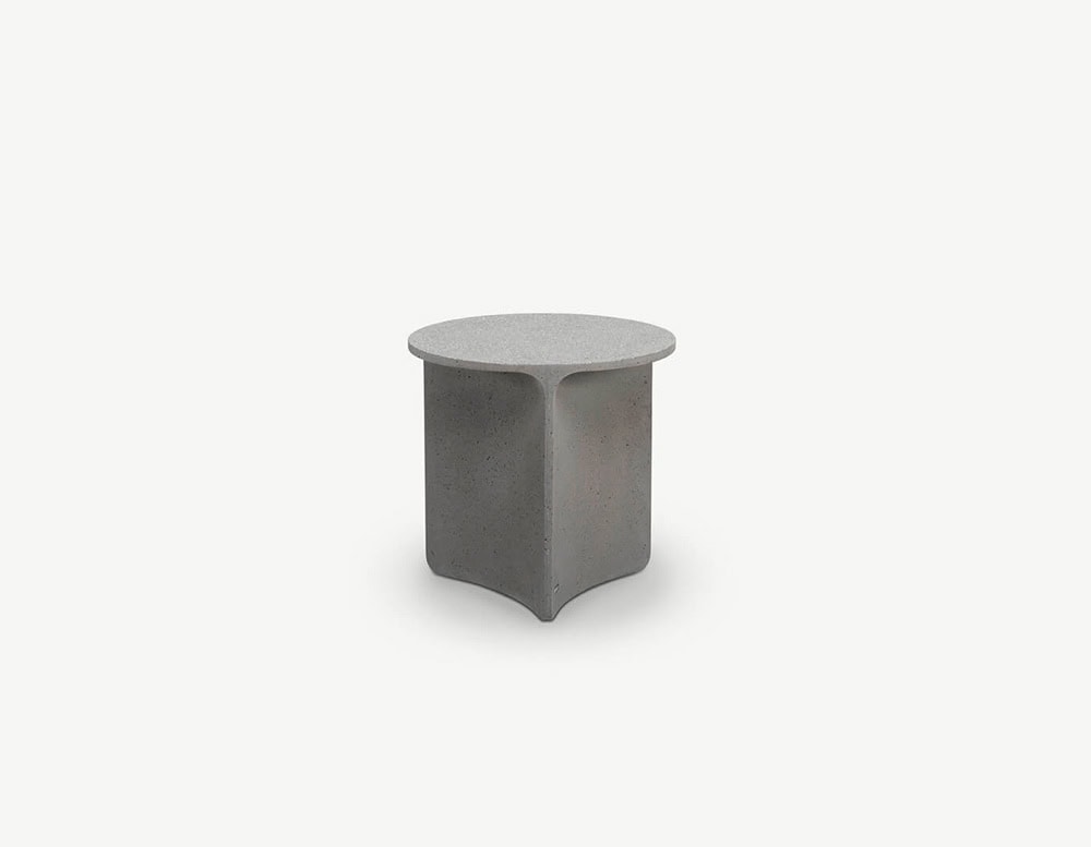 A round light grey coffee table with a sculpted medium grey base featuring three soft triangular segments.