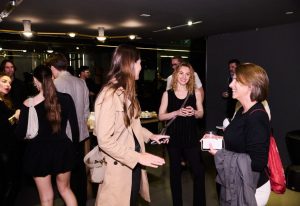 A lively evening at the showroom where guests mingle, share smiles, and enjoy drinks under soft lighting.
