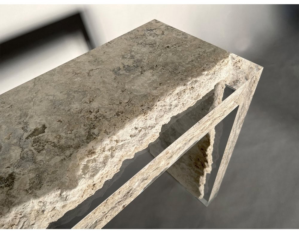 Detail of the Rapolano Console Table showcasing natural travertine edge embedded in clear acrylic. The contrast between rough stone and sleek material emphasizes its sculptural form.