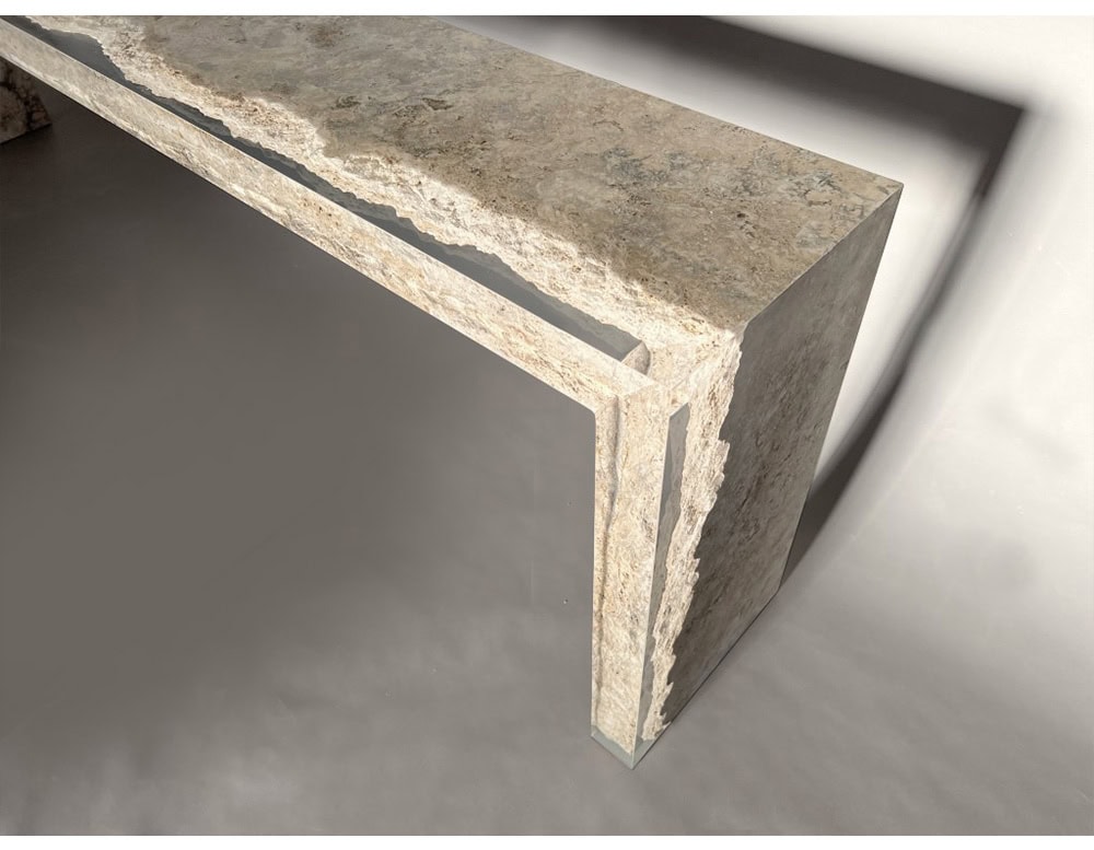 The Rapolano Console Table features a travertine slab with a natural split-edge detail and inset acrylic sides, creating a suspended visual effect that merges organic texture with sleek transparency.