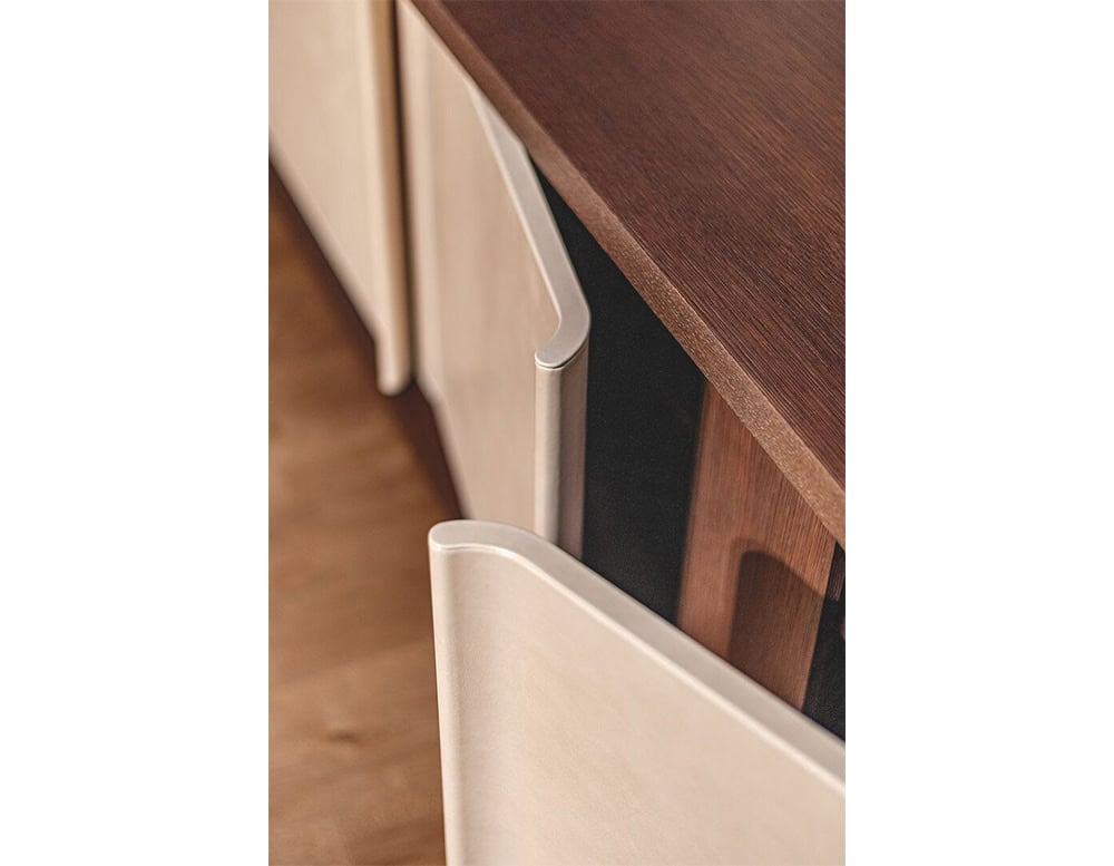 Close-up of the Bax Joni sideboard showing the finely detailed curved drawer fronts, which subtly overlap the dark wood frame. The contrast highlights the craftsmanship and material combination of the collection.