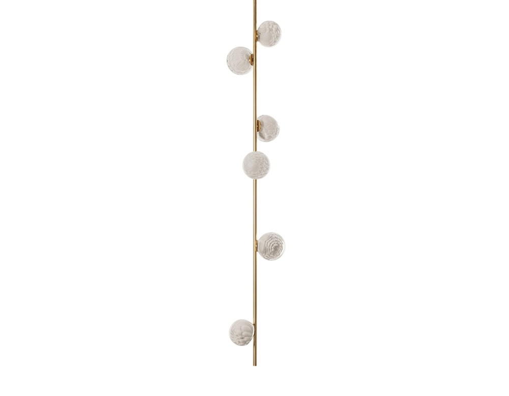 The Boc 118 Series vertical pendant features six hand-blown glass spheres arranged along a slim brass rod, creating a luminous and sculptural lighting element.