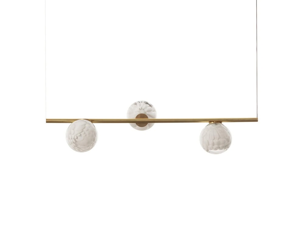 The Boc 118 Series horizontal pendant balances three textured glass spheres on a slim brass rod, creating a refined interplay of light, form and material.