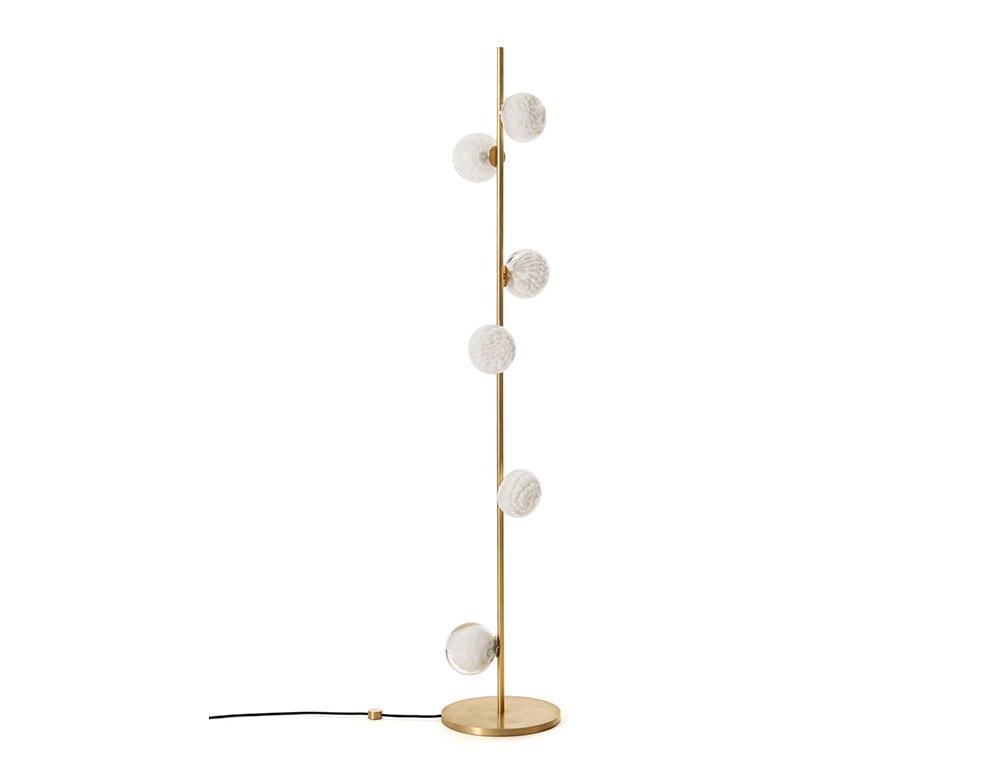 The Boc 118 Series floor lamp features a sleek brass stem adorned with hand-blown glass orbs, each with delicate textural details that create a warm, sculptural lighting statement.