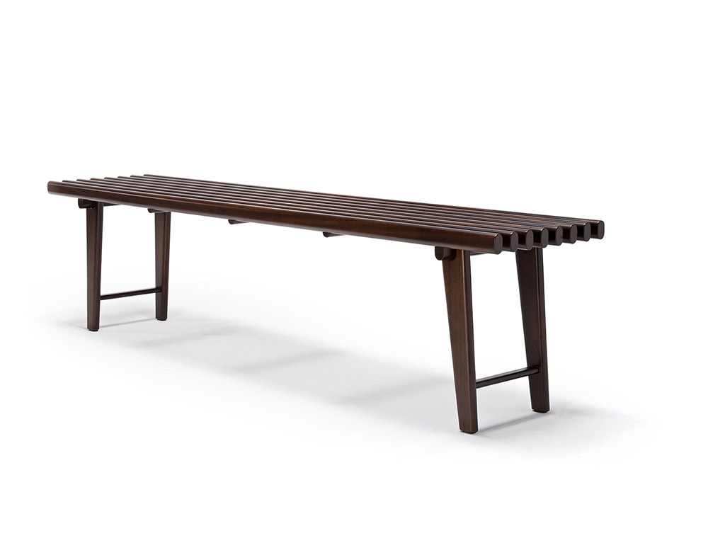 The Ext Elba Coffee Table Outdoor features an elongated slatted wood surface with rounded edges and tapered legs, offering a sleek and airy design ideal for outdoor lounging or dining areas.