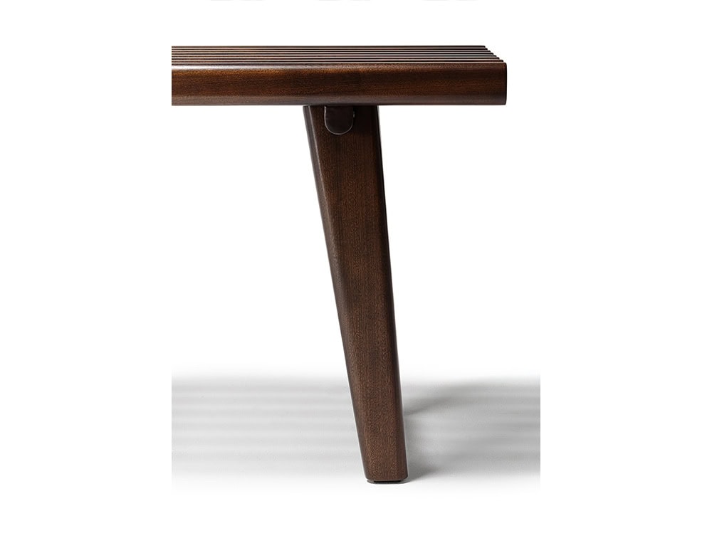 The Ext Elba Coffee Table Outdoor highlights its refined silhouette with rounded wood slats and an angled leg, offering stability and contemporary elegance for open-air living.