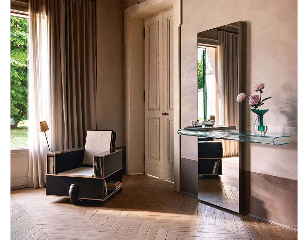 The Fiam Let Me See Mirror brings sculptural elegance with its sleek glass shelf and minimalist frame. It reflects light beautifully, enhancing a serene corner with natural textures and soft floral accents.