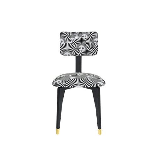A striking chair featuring bold black and white fan patterns accented with iconic faces, paired with sleek black legs and gold tips for a refined artistic statement.