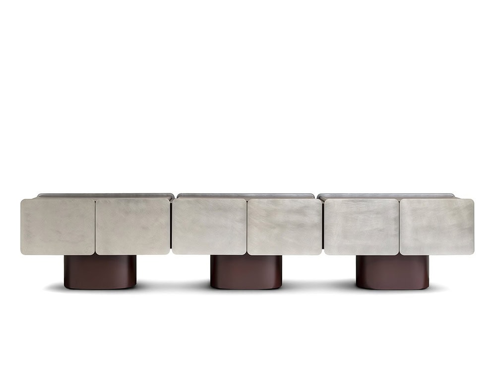 GR Admira Cabinet in an extended version with brushed silver-toned panels and deep brown cylindrical bases, combining sleek geometry with elegant material contrast.