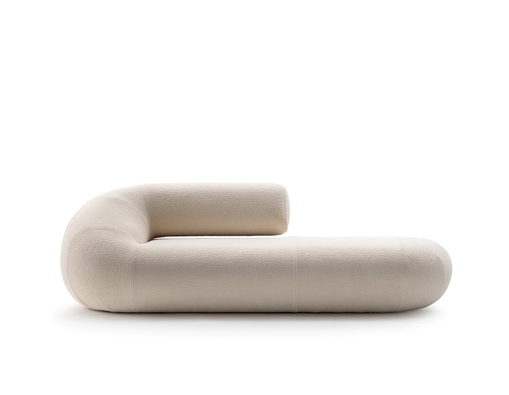 A single Evolis Sofa module showing its rounded cylindrical structure and curved backrest. The upholstery has a light, neutral tone with a subtly textured finish, enhancing the piece's soft and sculptural look.