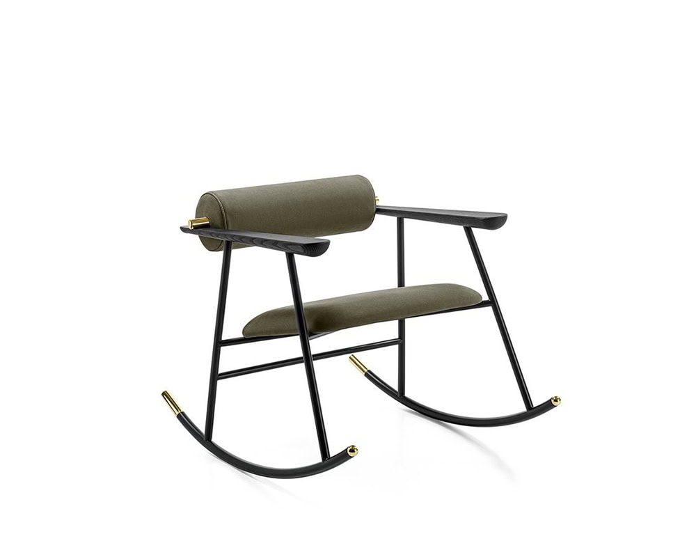 Lou Lou Rock Chair in matte black with olive green upholstery and brass-capped details. The sleek structure and gentle curves create a modern, airy silhouette against a white background.