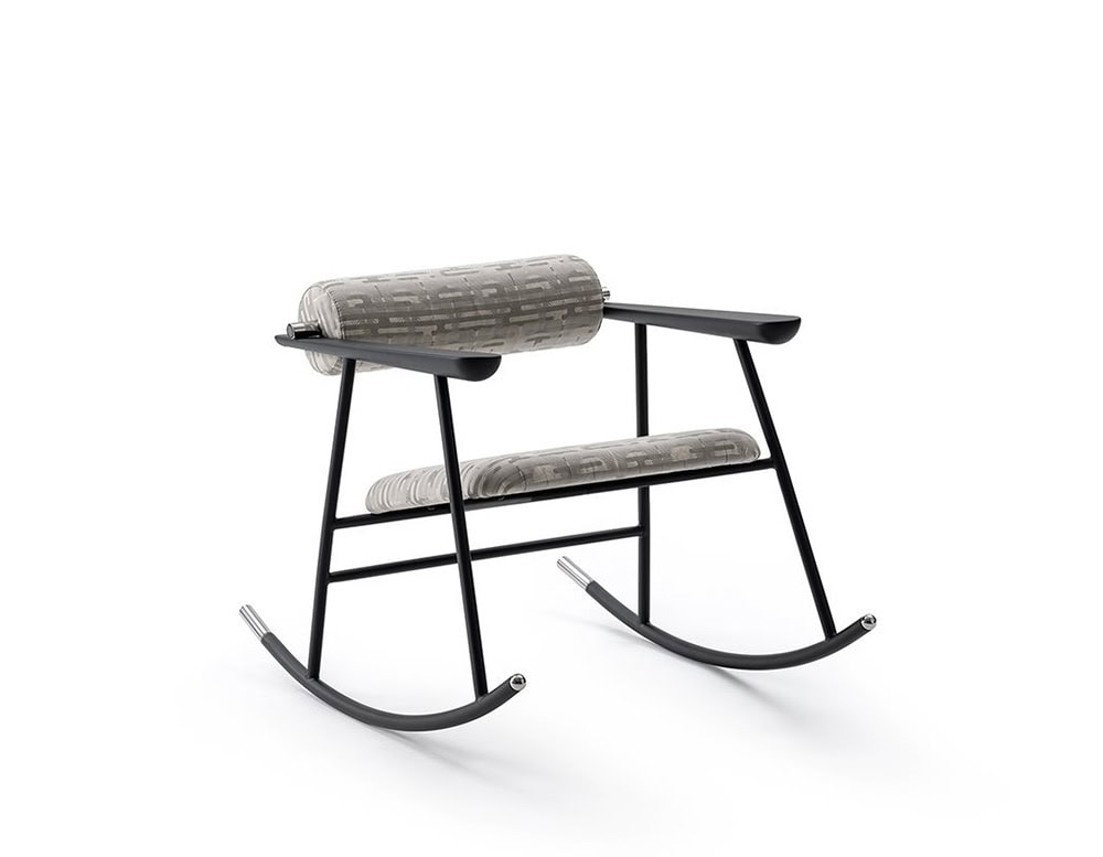 Lou Lou Rock Chair featuring a black metal frame with soft grey patterned upholstery. The cylindrical cushions and minimal lines create a graphic, modern look against a white backdrop.