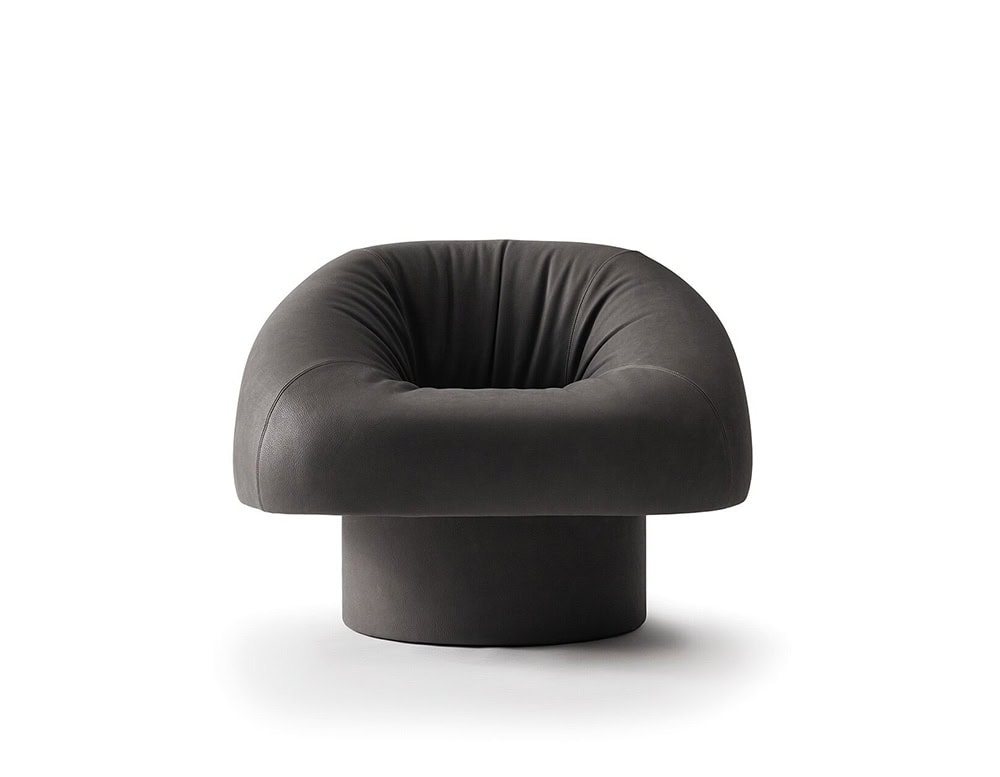 The GR Olivia Chair presents a generous, rounded seat with deep cushioning and soft curves, resting on a low cylindrical base for a distinctive and inviting lounge piece.