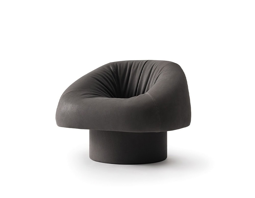 The GR Olivia Chair offers a bold silhouette with its plush, curved backrest and thick, rounded seat resting on a cylindrical base, creating an enveloping and sculptural presence.