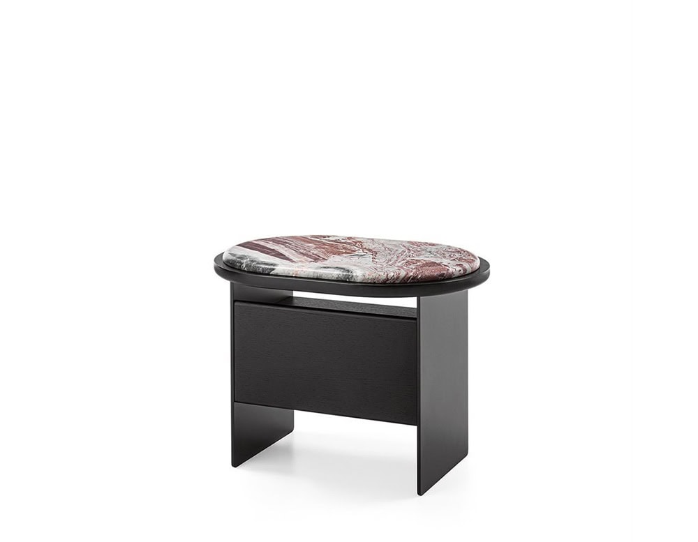 The GR Sensei Night Table features a bold red marble top with natural veining, contrasted by a matte black oak structure. Its sleek design and concealed drawer offer both style and discreet functionality for contemporary interiors.