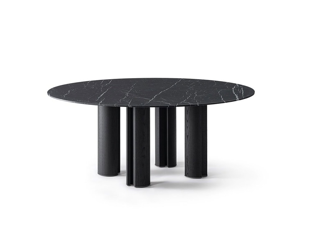 The GR Simpodio W Table presents a sculptural silhouette with its rounded top and multiple column legs. The dark marble surface, veined in subtle white, contrasts elegantly with the matte black base, adding refined presence to the space.