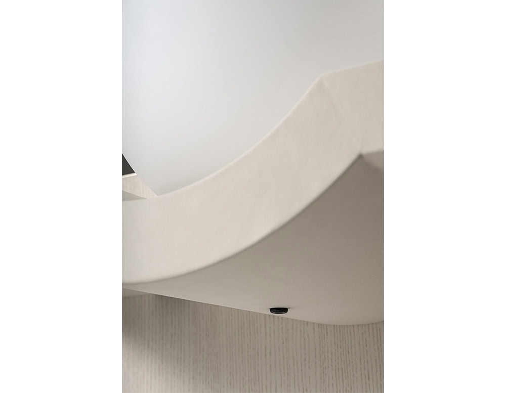 The GR Stresa Console Table reveals a close-up of its sculpted light sphere nestled into a smooth off-white shelf, highlighting the refined curves and texture of the craftsmanship.