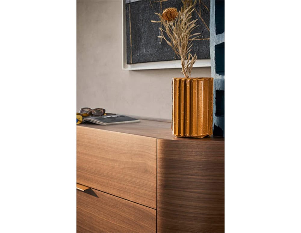 The Pian Dedalo Nightstand highlights refined craftsmanship with its smooth wood grain, rounded edges and minimalist handle, elegantly styled with simple objects for a warm modern look.