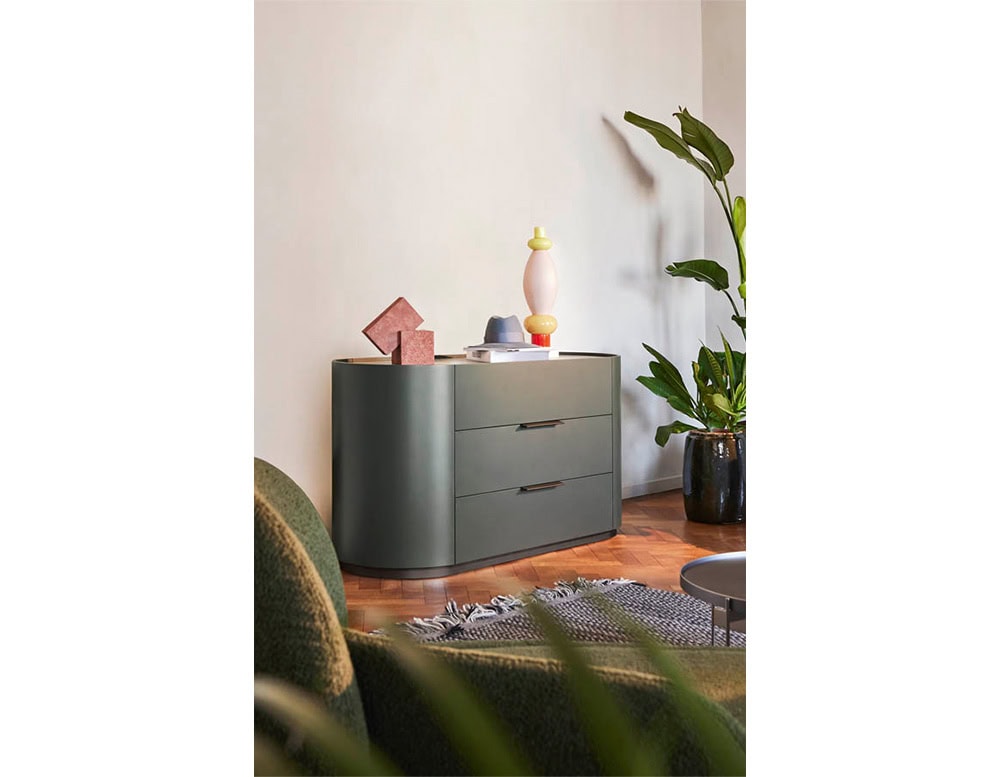 The Pian Dedalo Nightstand comes with a refined stone top and seamlessly integrated curved storage, blending elegant materials with smart functionality beside a warm and relaxed bedroom setup.