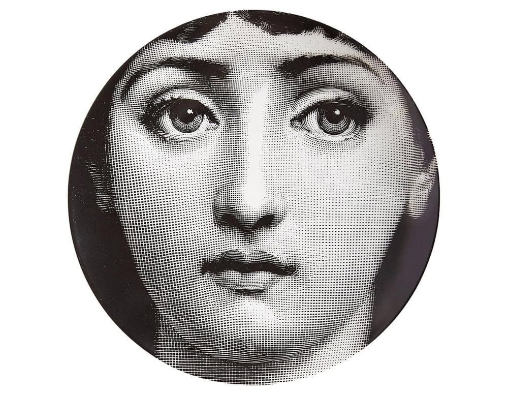 A porcelain plate featuring a high contrast black and white portrait. The expressive gaze and delicate details give it a timeless surreal presence, ideal as a wall mounted art object or tabletop accent.