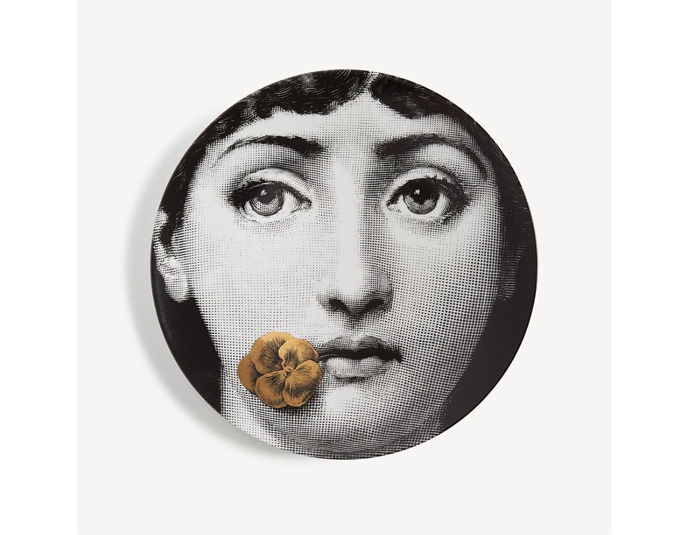 A porcelain plate featuring a black and white portrait with a golden bloom gently resting near the lips. The expressive composition adds a touch of poetic intrigue, perfect as a wall mounted object or as a statement tabletop piece.