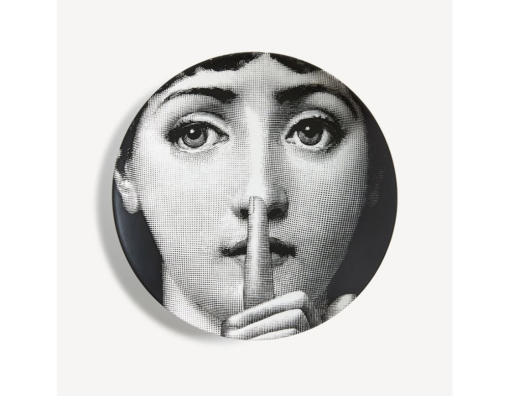 A captivating black and white plate showcasing a woman's face holding a finger to her lips in a timeless 