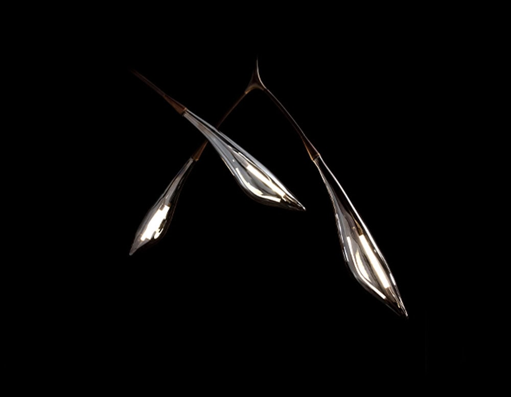 This Hen Maple Ceiling Light captures an organic essence through fluid, sculptural arms and elongated glass shades. Its graceful silhouette blends form and function, delivering warm illumination with artistic finesse.
